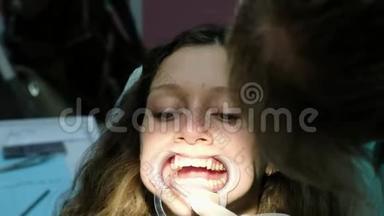 牙医把棉花放进嘴里，助手在安装之前从唾液喷射器中取出唾液